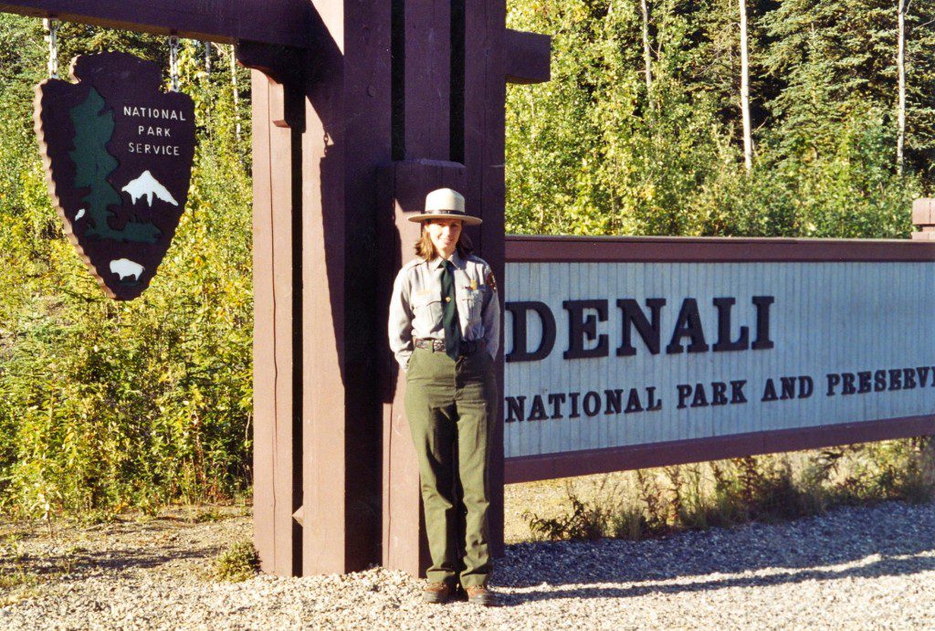 A man standing in front of the entrance to denali national park.