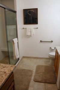 A bathroom with a toilet, shower and sink.