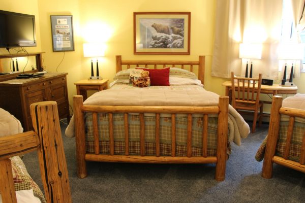 A bed room with a nice wooden frame and a lot of pillows