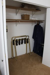 A closet with shoes hanging on the rack.
